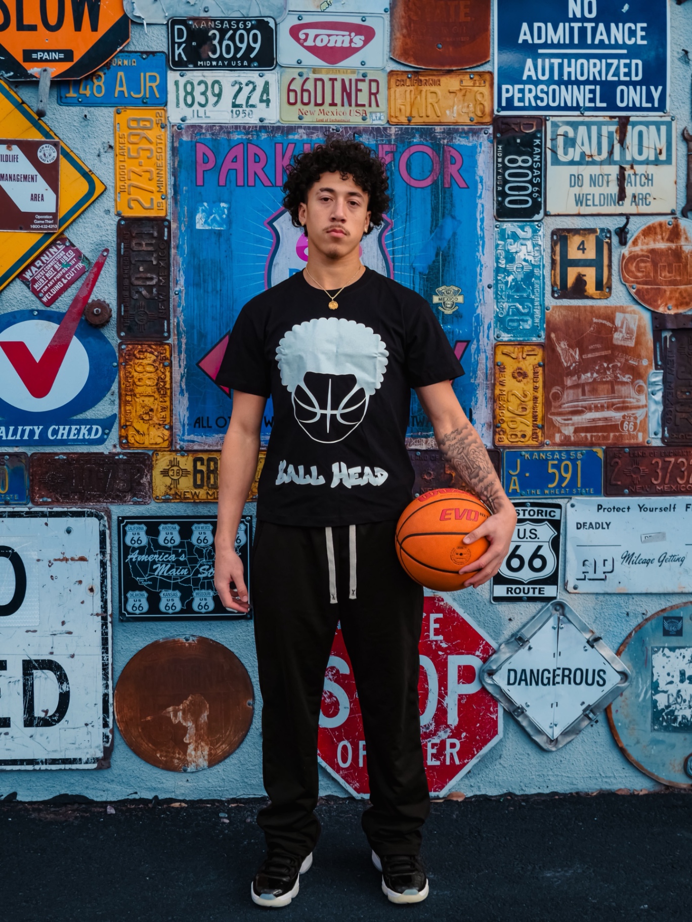 Black BallHead Hoops tee with white afro basketball logo, worn with a basketball