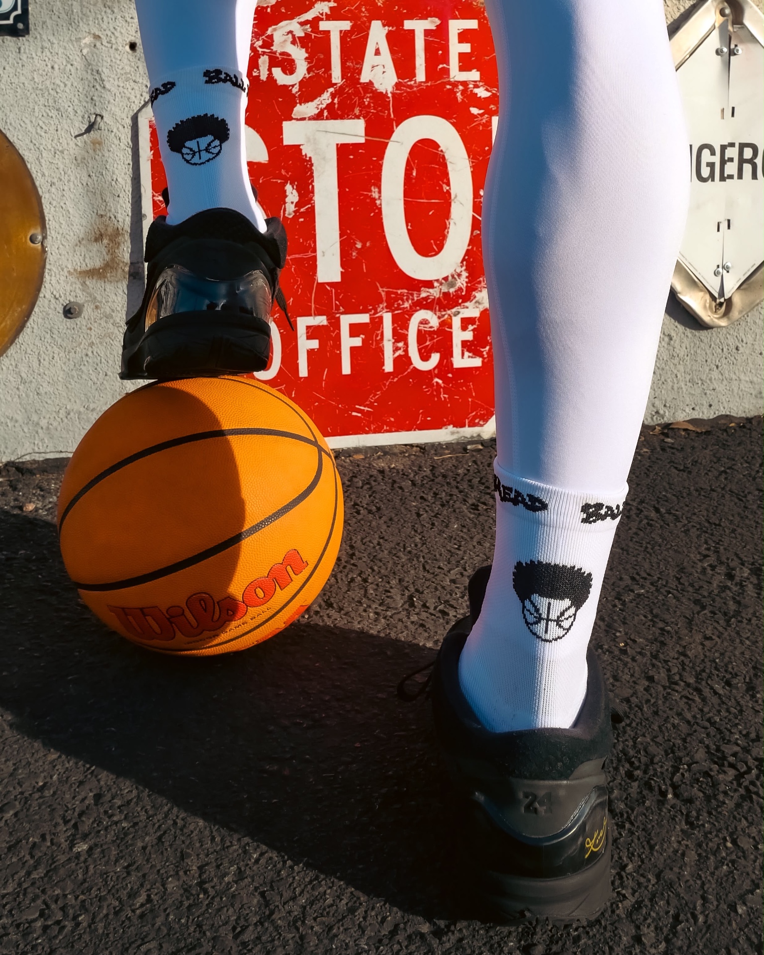 White BallHead crew socks with black afro basketball logo and BallHead cuff, worn on court